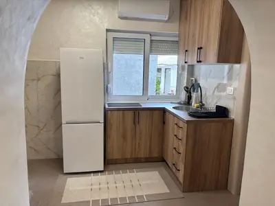 a kitchen with a white refrigerator and a window at Max Apartments in Podgorica
