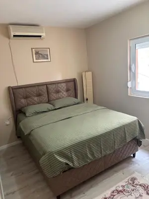 a bedroom with a bed with a green comforter at Max Apartments in Podgorica