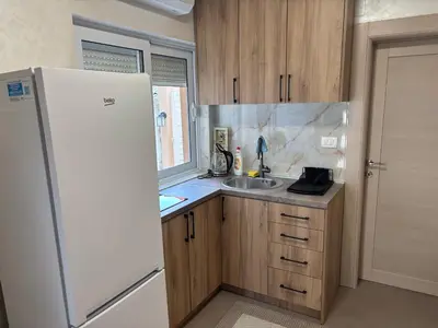 a kitchen with a white refrigerator and a sink at Max Apartments in Podgorica