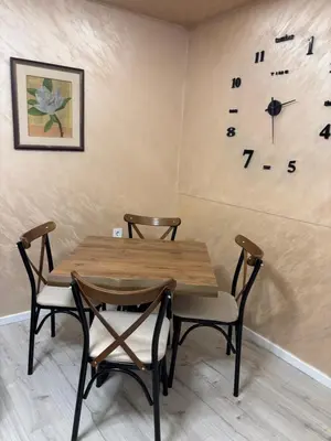 a table and chairs with a clock on the wall at Max Apartments in Podgorica