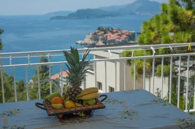 a basket of fruit on a table on a balcony at Apartments Peđa in Sveti Stefan