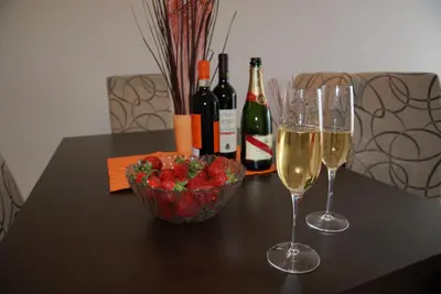 a table with two glasses of wine and a bowl of strawberries at Belveder Alevtina in Rafailovici