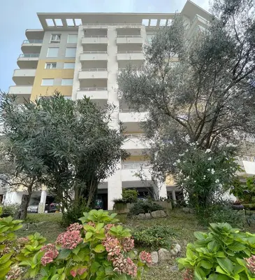 a large white building with trees in front of it at Belveder Alevtina in Rafailovici