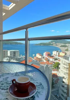 a cup of coffee sitting on a table in front of a window at Belveder Alevtina in Rafailovici