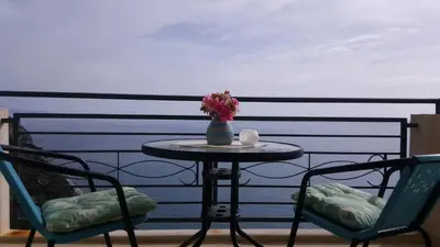 a table with a vase of flowers on a balcony at Lighthouse Apartments in Budva