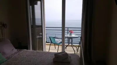 a bedroom with a bed and a table and a balcony at Lighthouse Apartments in Budva