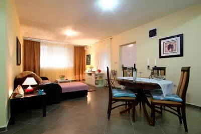 a living room with a couch and a table with chairs at Lighthouse Apartments in Budva
