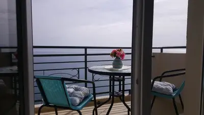a balcony with a table and chairs and a vase of flowers at Lighthouse Apartments in Budva