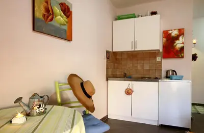 a room with a table and a kitchen with white cabinets at Lighthouse Apartments in Budva