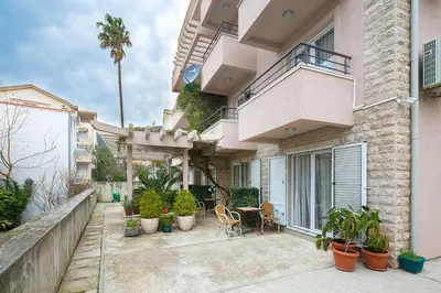 a house with a patio with plants and a table at Petrovac Holiday Apartments in Petrovac na Moru