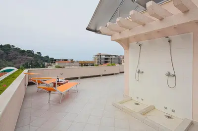 a patio with a table and chairs on a roof at Petrovac Holiday Apartments in Petrovac na Moru