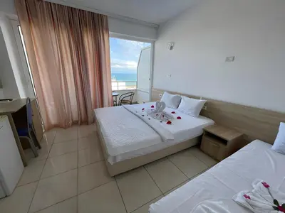 a hotel room with two beds and a balcony at Rosa Negra in Ulcinj
