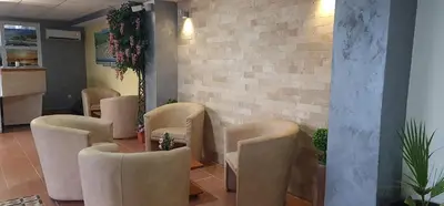 a waiting room with chairs and a table and a brick wall at Rosa Negra in Ulcinj