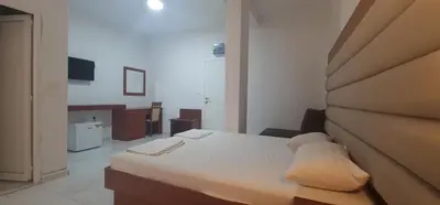 a bedroom with a white bed with a head board at Rosa Negra in Ulcinj