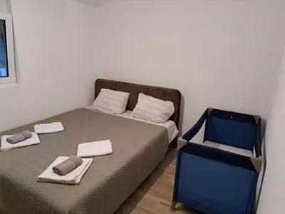 a small bedroom with a bed with towels on it at Apartmani EMMA in Kotor