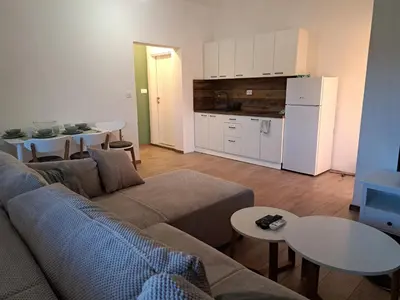 a living room with a couch and a kitchen at Apartmani EMMA in Kotor