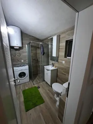a bathroom with a shower and a toilet and a sink at Apartmani EMMA in Kotor