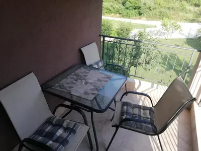 a table and chairs on a balcony with a view at Apartmani EMMA in Kotor