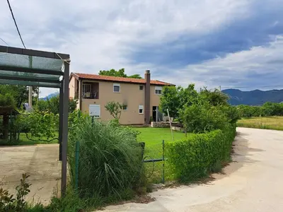 a house with a fence next to a road at Apartmani EMMA in Kotor