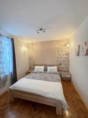 a bedroom with a large bed and a window at Cozy Little House Kotor in Kotor