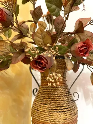 a wicker vase with flowers in it at Cozy Little House Kotor in Kotor