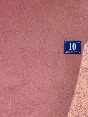 a blue sign on the side of a red wall at Cozy Little House Kotor in Kotor