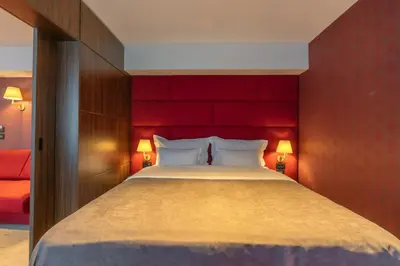 a bedroom with a large bed with a red headboard at HOTEL AGAPE in Bar