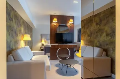 a living room with white furniture and a television at HOTEL AGAPE in Bar