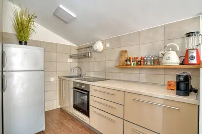 a kitchen with a white refrigerator and a sink at Cozy rooftop apartment with the city view in Budva