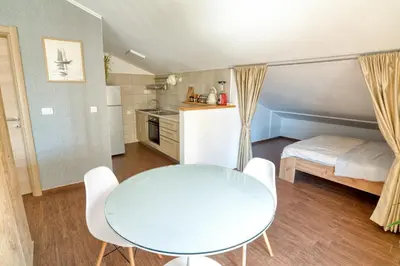 a small apartment with a table and a bed at Cozy rooftop apartment with the city view in Budva