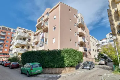a small green car parked in front of a building at Cozy rooftop apartment with the city view in Budva