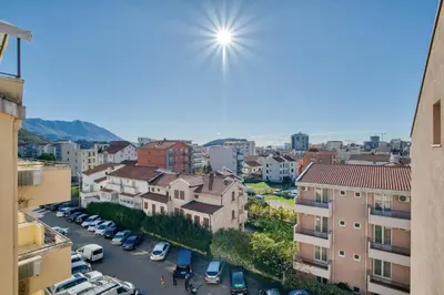 a view of a city with cars parked in a parking lot at Cozy rooftop apartment with the city view in Budva