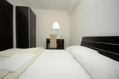 a bedroom with two white beds and a mirror at Apartments Anita in Budva