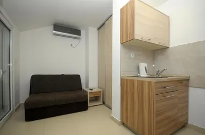 a bathroom with a sink and a chair in a room at Apartments Anita in Budva