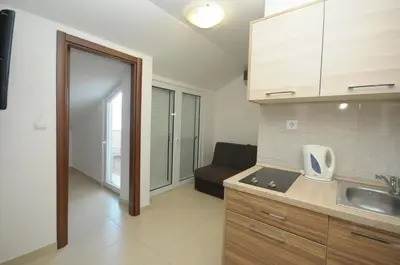 a kitchen with a sink and a couch in a room at Apartments Anita in Budva