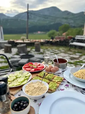 a table with plates of food on top of it at Rustic house Pojata in Njeguši