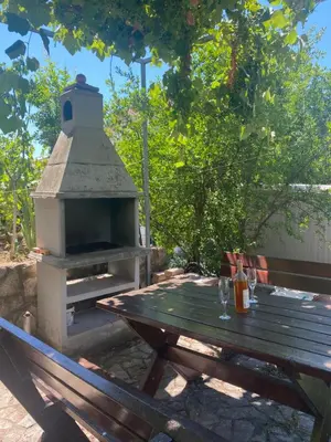 a picnic table with a pizza oven in a backyard at Sunny Villa Apartments in Budva