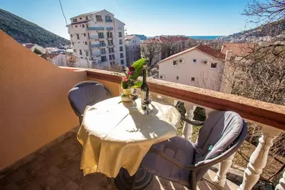 a table and chairs on a balcony with a bird at Sunny Villa Apartments in Budva