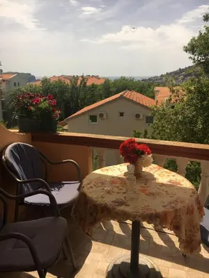 a table with a vase of flowers on a balcony at Sunny Villa Apartments in Budva