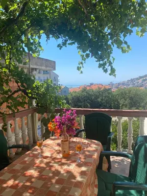 a table with wine glasses and flowers on a balcony at Sunny Villa Apartments in Budva