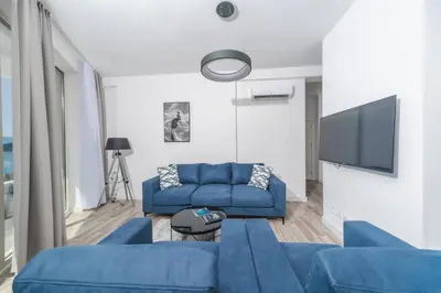 a living room with blue couches and a flat screen tv at Skyline Vista in Becici
