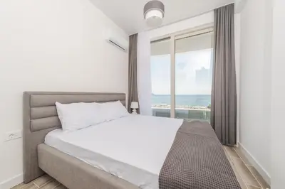 a bedroom with a bed and a large window at Skyline Vista in Becici