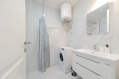 a white bathroom with a toilet and a sink at Skyline Vista in Becici