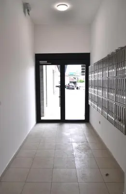 an empty hallway with a door and a tile floor at White Cloud by Rent a Car MI in Podgorica