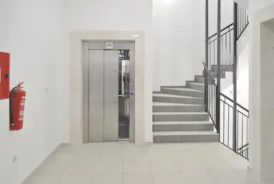 a hallway with a door and stairs in a building at White Cloud by Rent a Car MI in Podgorica