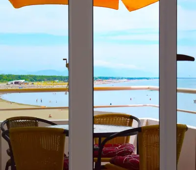 a table and chairs with a view of the beach at Apartments Kepi Gjerana in Ulcinj