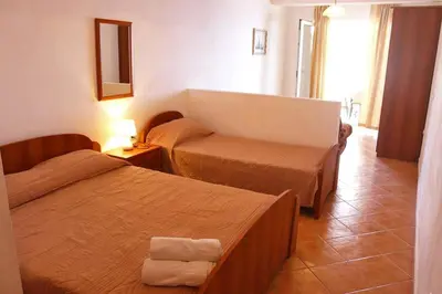a hotel room with two beds and a mirror at Apartments Kepi Gjerana in Ulcinj