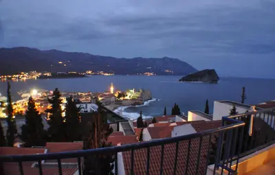a view of a town in the water at night at Belvedere Apartments in Budva
