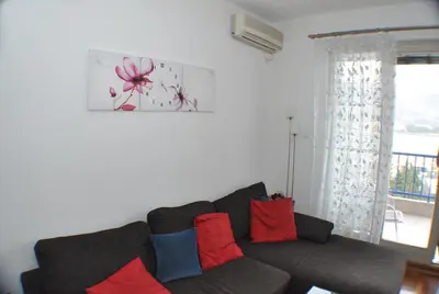 a living room with a couch with red and blue pillows at Belvedere Apartments in Budva