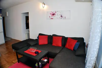 a living room with a couch with red and blue pillows at Belvedere Apartments in Budva